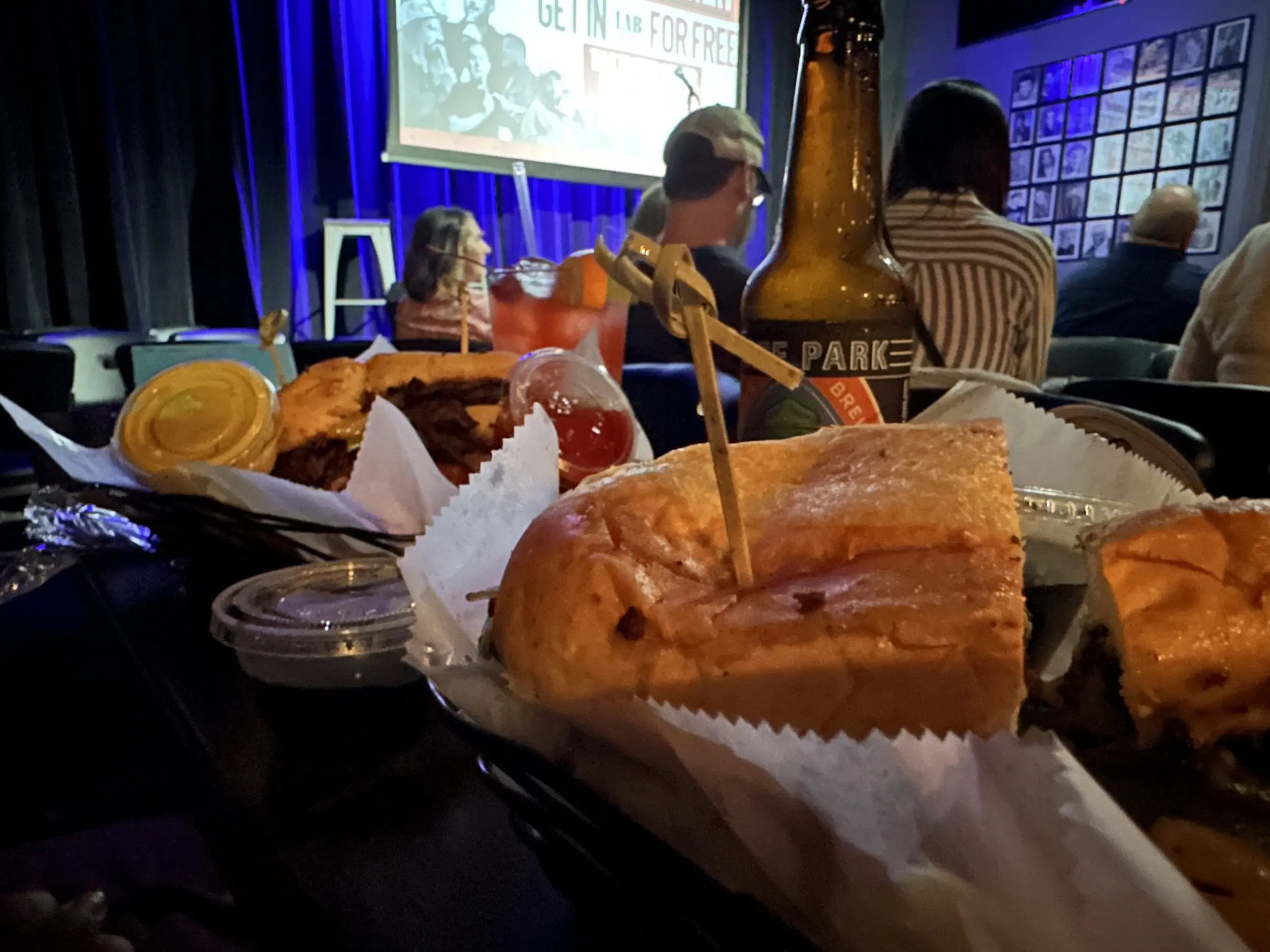 Photo of french dips, beer, and a stage